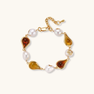 Gold plated bracelet with amber and honey teardrop stones, baroque freshwater pearls with gold flecks, and an adjustable chain.