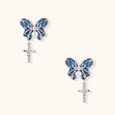 Pair of silver-tone butterfly earrings with blue denim wings, a spider accent, white bead, clear stone and dangling cross charm.