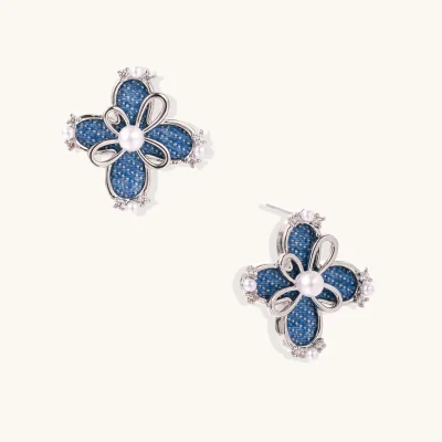 Pair of silver-tone four-petal flower stud earrings with blue denim fabric petals, a center white bead and zirconia accents.