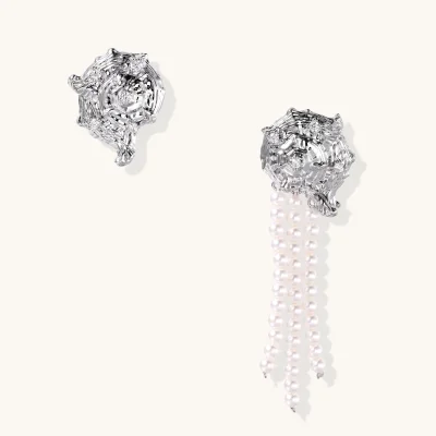 Asymmetric earring pair: textured white gold plated shell studs with zirconia, one with three strands of white beads.