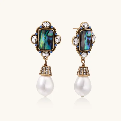 Pair of vintage-style gold plated drop earrings with iridescent abalone shell panels, clear and blue crystals, and white teardrop beads.