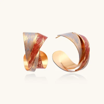 Sculptural gold-plated hoop earrings with diagonal purple and coral enamel stripes in twisted ribbon design
