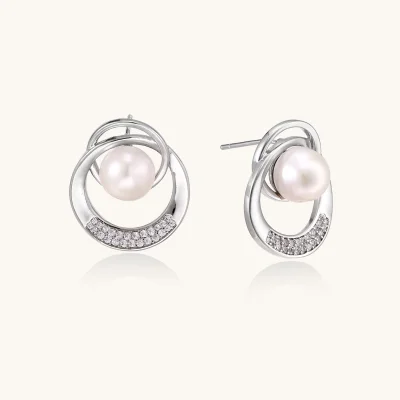 White gold-plated brass earrings with circular design, freshwater pearl center, and diamond accents
