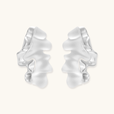 Pair of silver-toned sculptural earrings with flowing abstract forms and stud backs against white background.