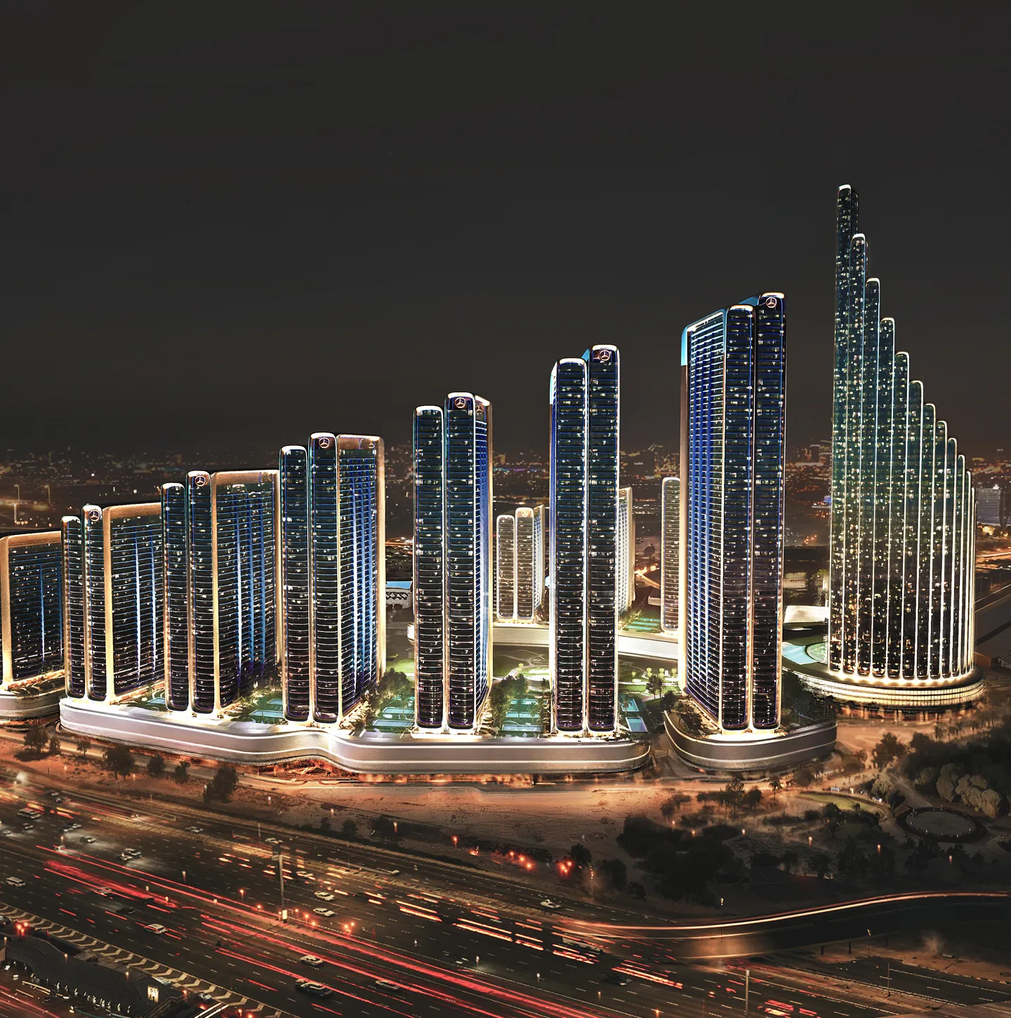 Night view of a modern city skyline with a group of illuminated high-rise buildings featuring Mercedes-Benz logos and busy highway traffic in the foreground.