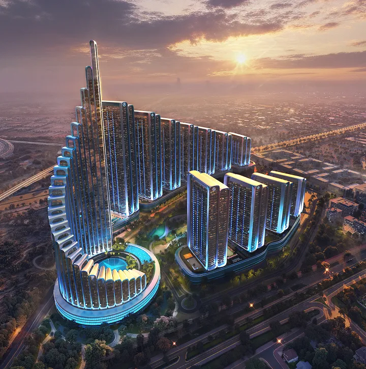 Aerial view of a modern high-rise building complex with curved and linear towers illuminated in blue at sunset.