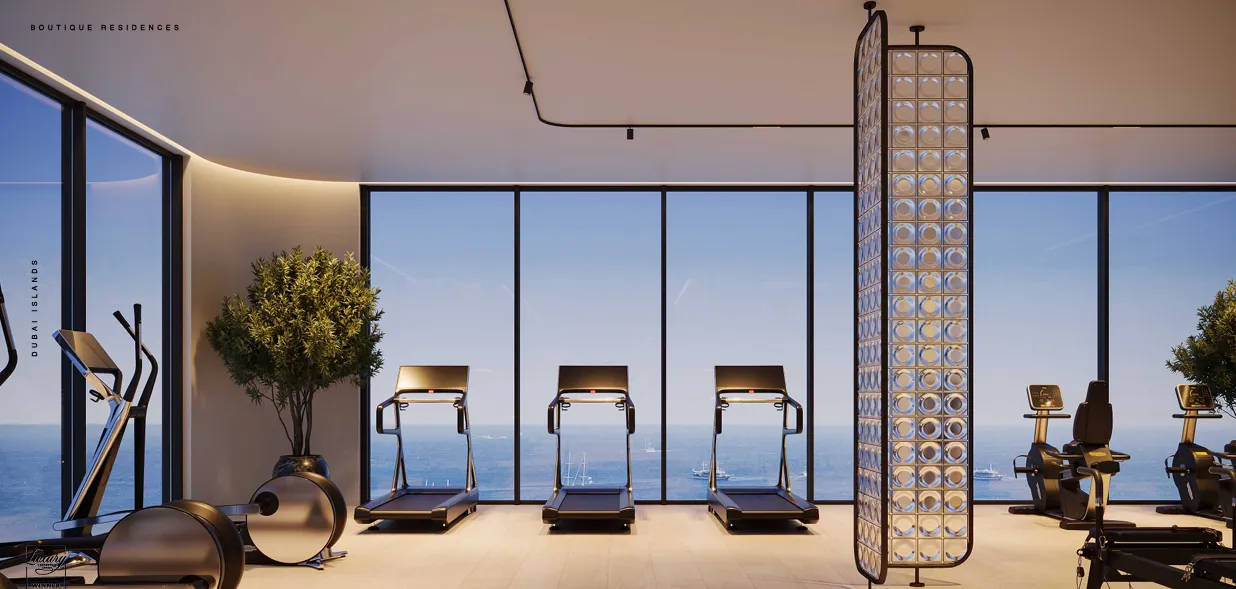 Modern gym with treadmills, exercise bikes, and large glass windows overlooking the ocean.