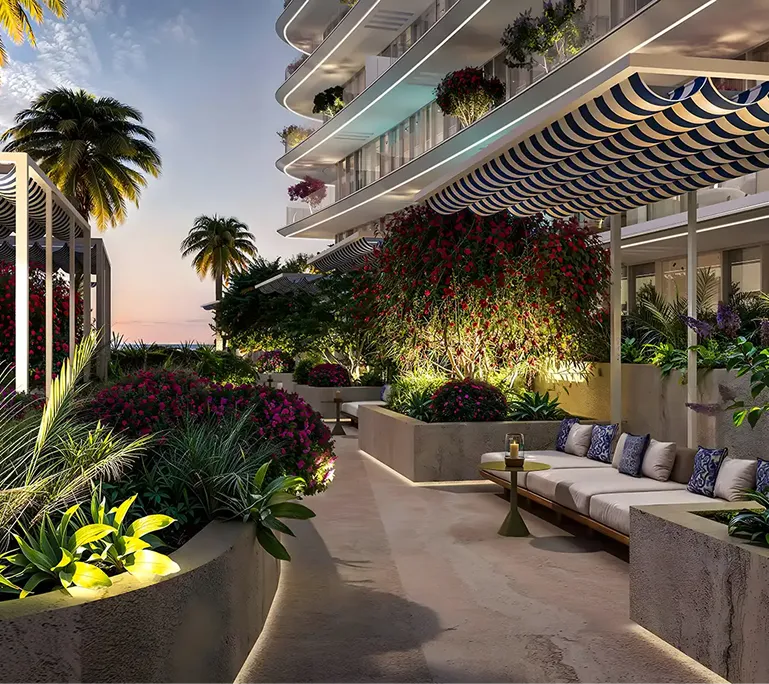 Modern outdoor terrace with cushioned seating, striped canopy, lush plants, and palm trees during sunset.