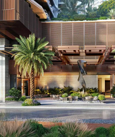 Modern outdoor seating area with metal tables and chairs under wooden lattice awnings, a central abstract sculpture, and surrounded by palm trees and greenery.