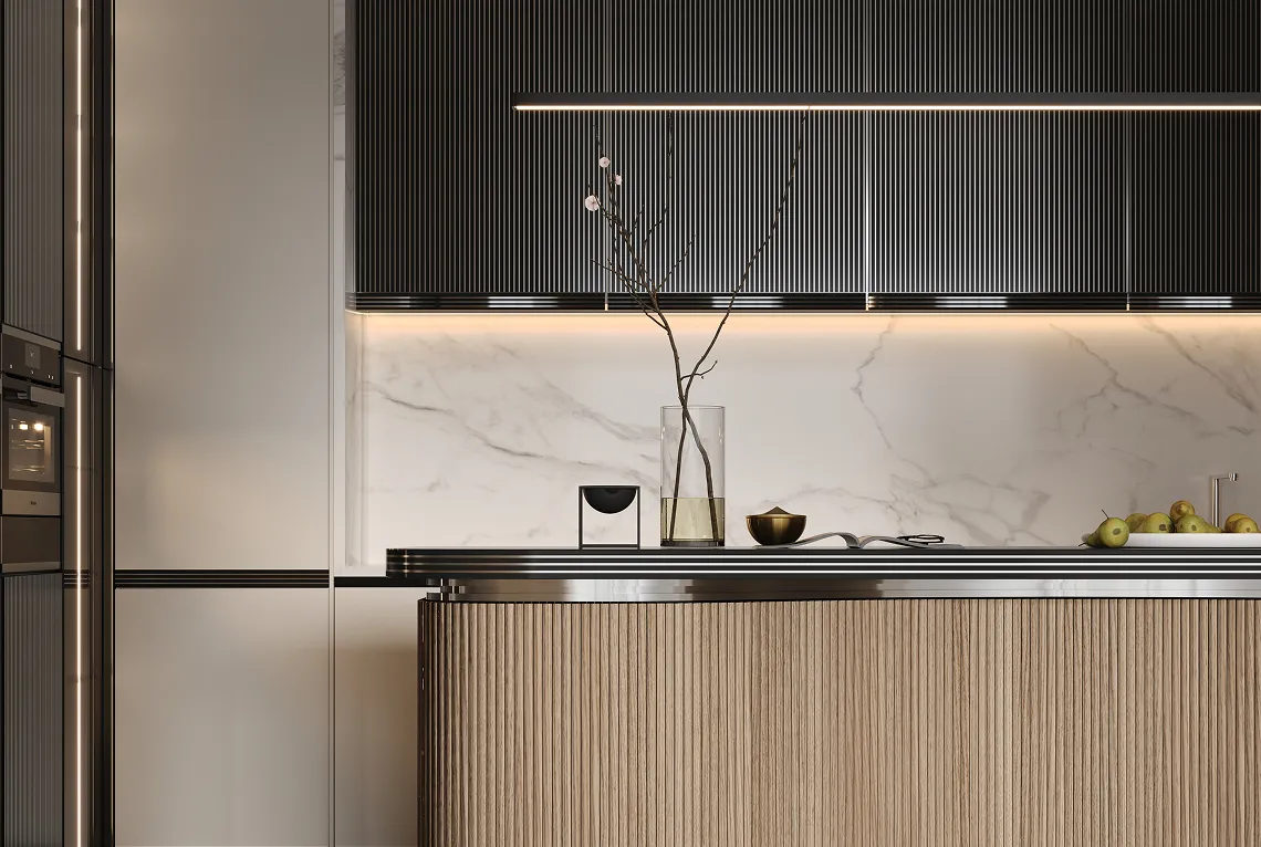 Modern kitchen with ribbed wooden island, black vertical cabinets, marble backsplash, and minimalist decor including a glass vase with branches and a bowl of green apples.