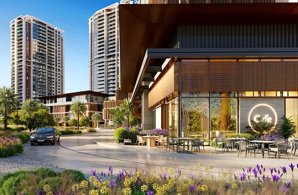 Modern outdoor café seating area with tables, chairs, and plants in front of a building with large windows and high-rise apartments in the background.