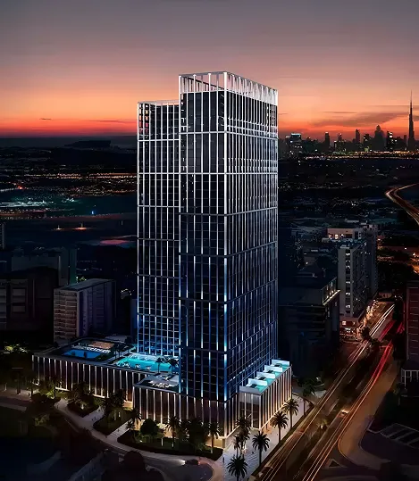 Modern skyscraper illuminated with vertical lights at dusk, with cityscape and sunset in the background.