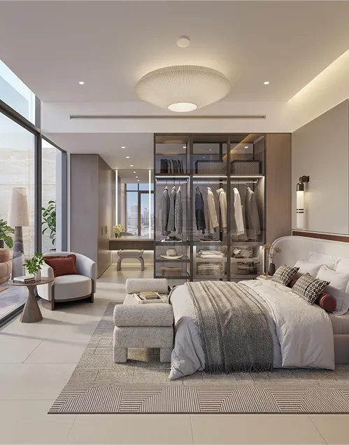 Modern bedroom with large glass wardrobe, king-sized bed with grey and white bedding, lounge chair, and city view through floor-to-ceiling windows.