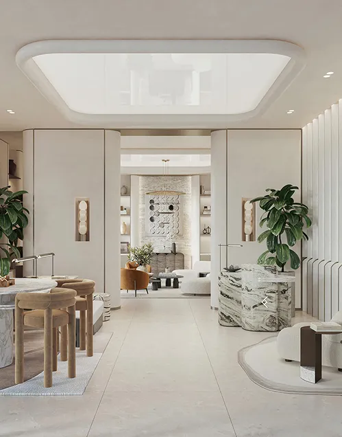 Elegant modern living space with beige tones featuring curved marble countertops, wooden stools, indoor plants, and cozy seating around a stone fireplace.