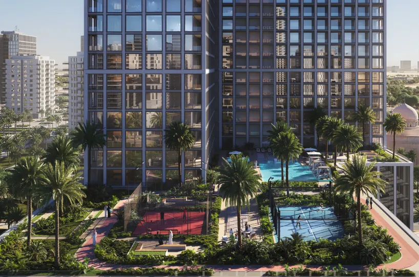 Modern residential complex with two tall glass buildings, palm trees, a red basketball court, a blue tennis court, and a swimming pool between the buildings.