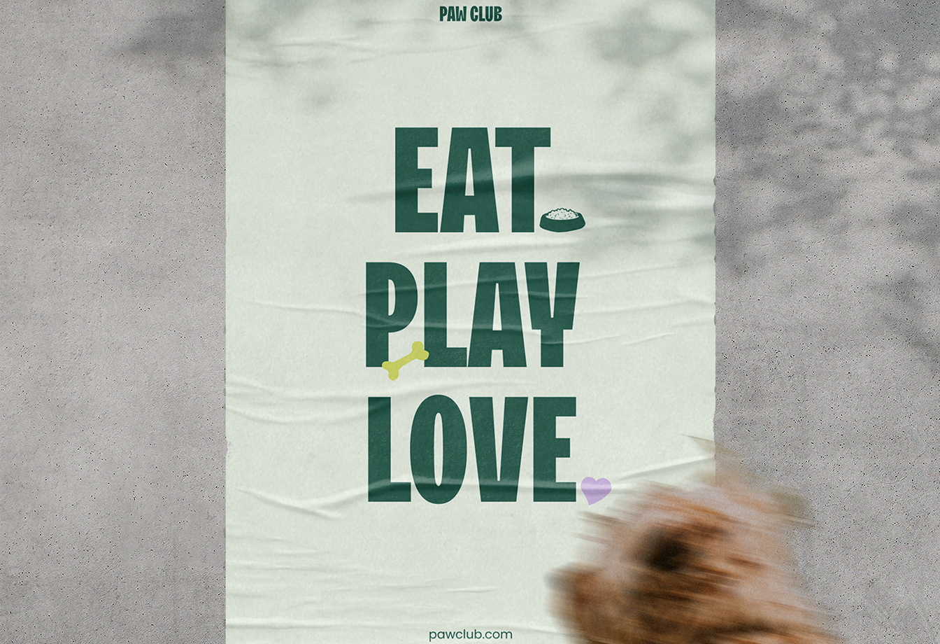 Poster on a concrete wall with text 'PAW CLUB' and 'EAT PLAY LOVE' accompanied by icons of a dog food bowl, a bone, and a heart, with a blurred dog in the foreground.