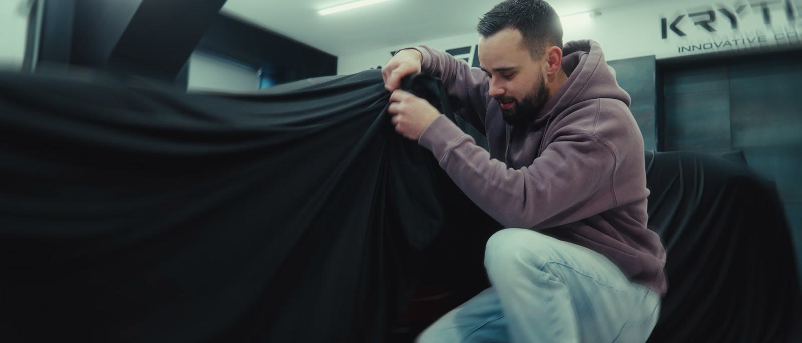 La housse noire tirée sur la Ford GT dans l’atelier