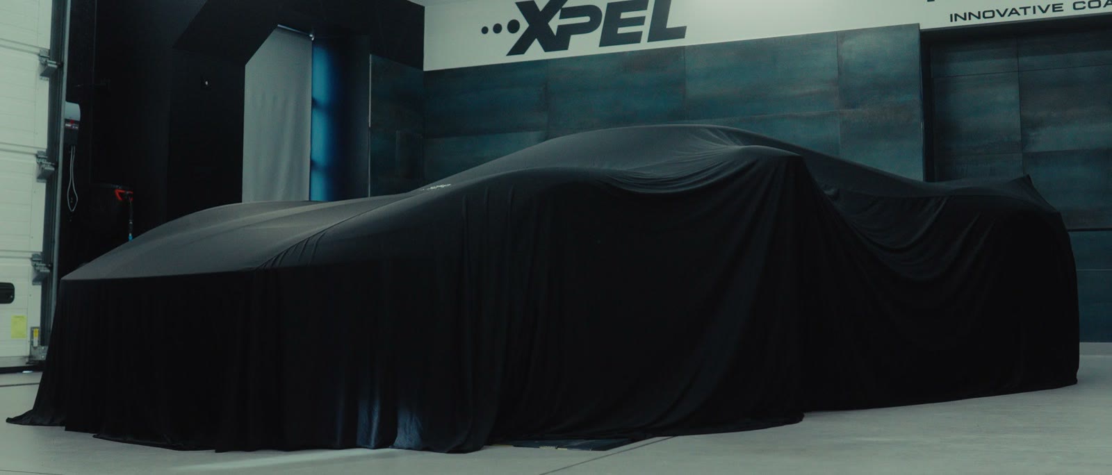 La Ford GT encore sous sa housse, devant le mur XPEL