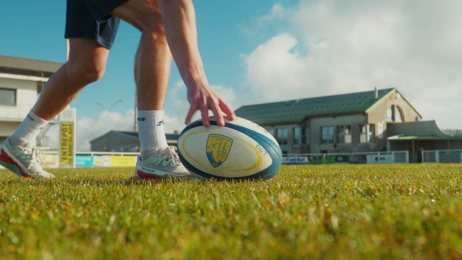 Un joueur pose le ballon de rugby sur la pelouse