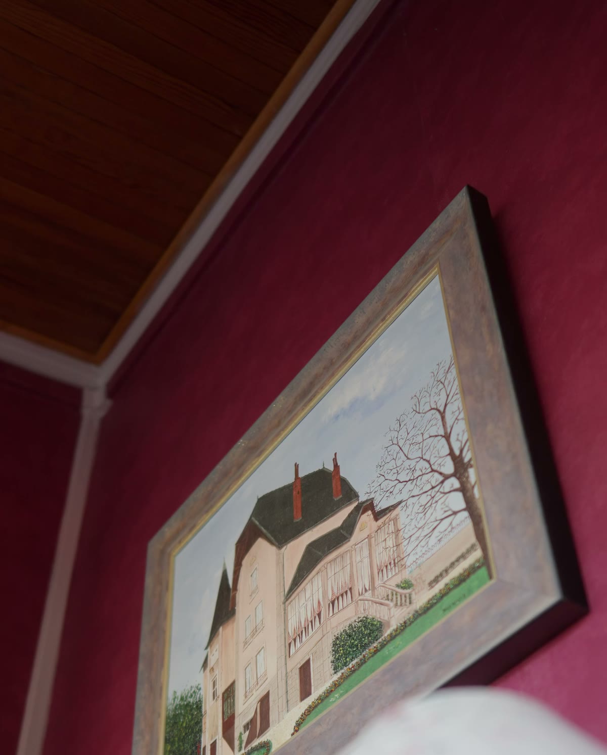 Un tableau de la maison, encadré sur un mur grenat