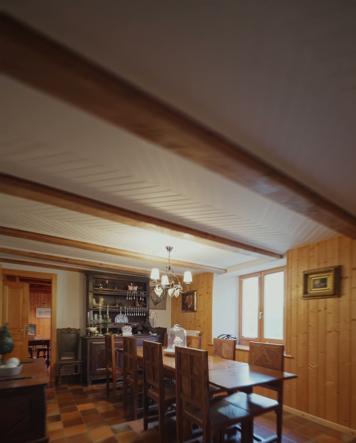 La salle à manger, ses fenêtres et sa table de bois