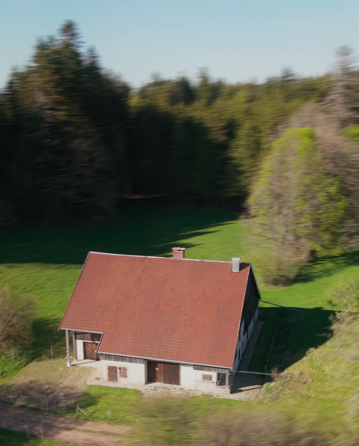 La ferme dans son pré, la forêt derrière, vue du drone