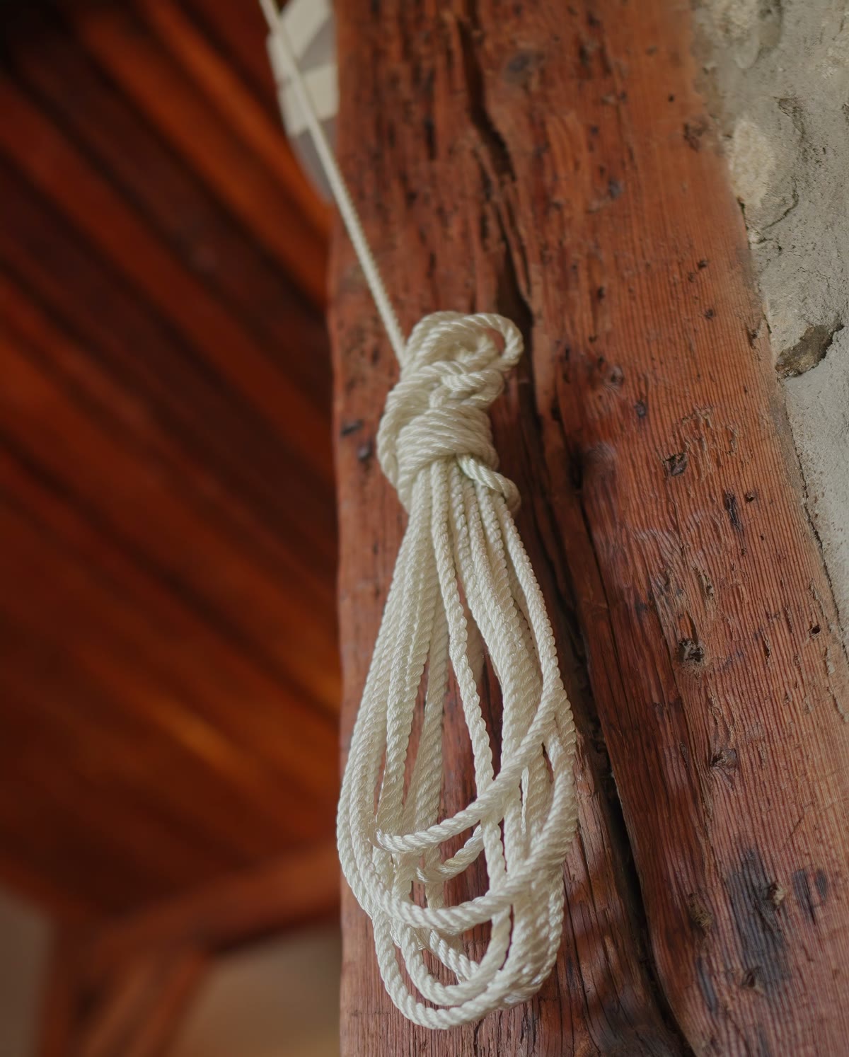 Une corde enroulée sur une poutre ancienne