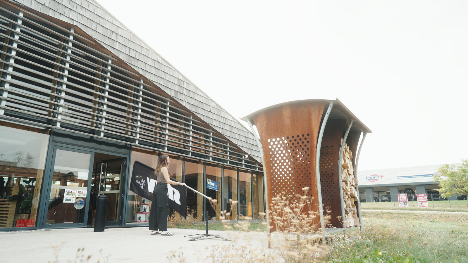 La façade du bâtiment, ses lames de bois et l’entrée