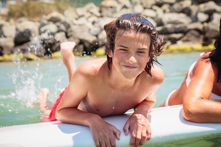 Happy private school student floating on the water