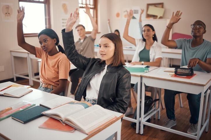 A student attending a Swiss boarding school raising her hand in class