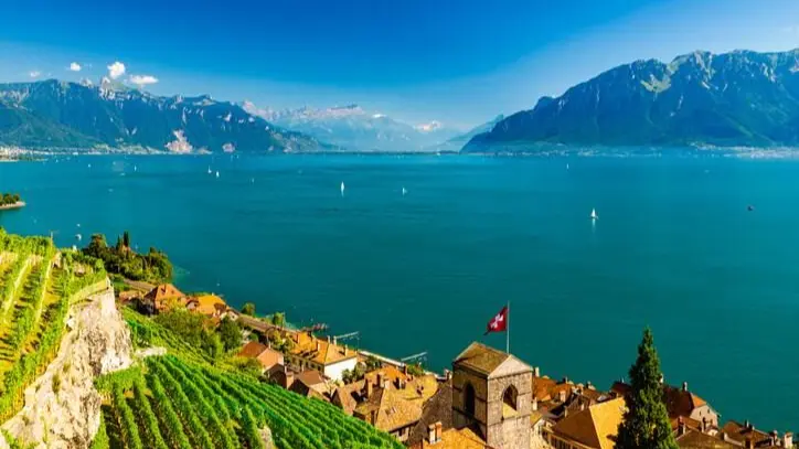 Wide exterior shot of Lake Geneva overlooking Lausanne or Lake Geneva, with students walking together