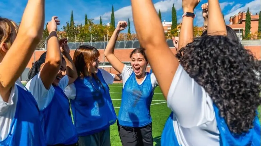 A group of boarding students celebrates together after a competitive  team sports match
