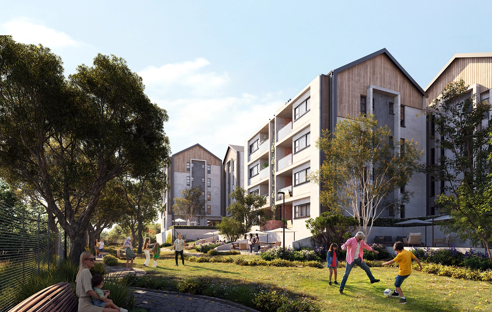 Modern apartment buildings with sloped roofs and an outdoor green space where people, including children and adults, are playing and socializing under trees.
