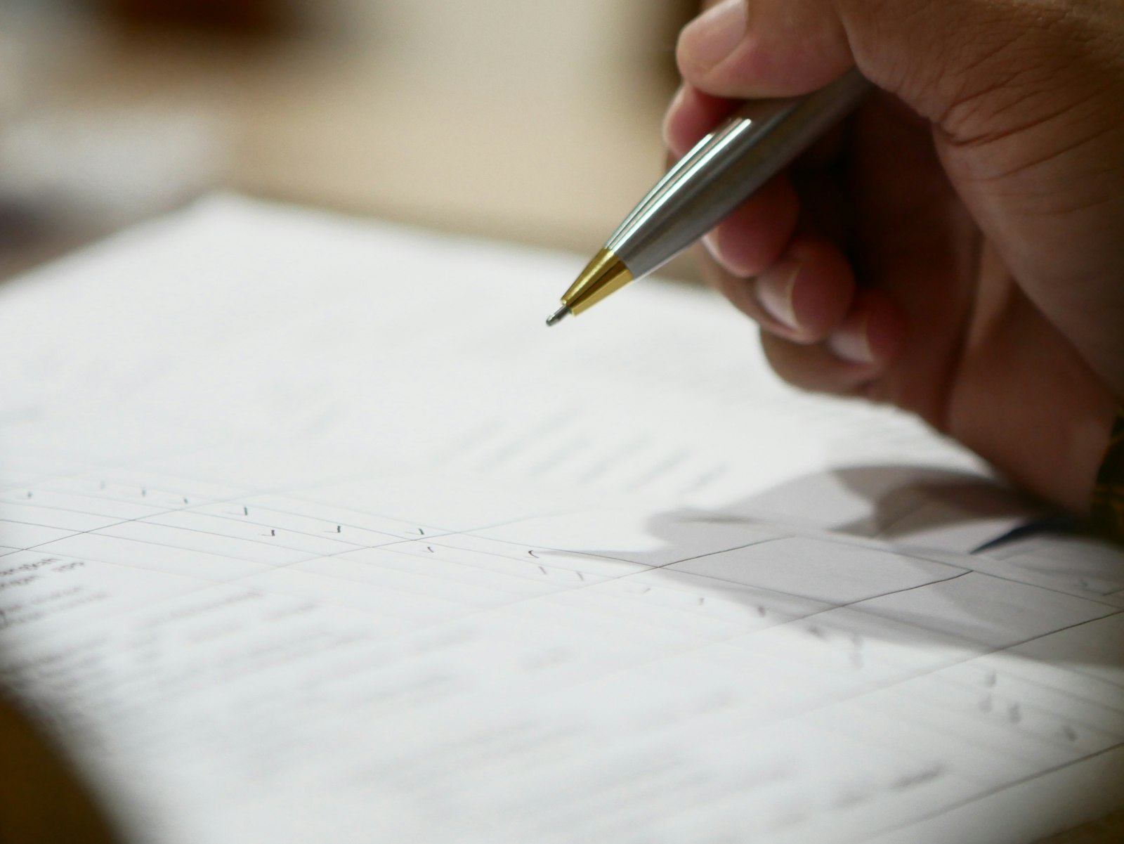 Main tenant un stylo au-dessus d'un document, symbole du consentement et de la conformité