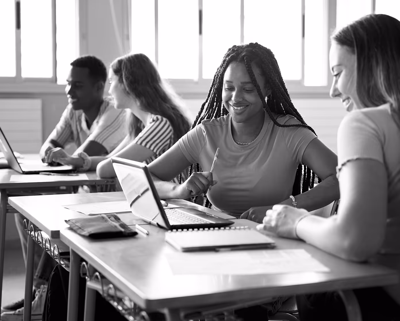 Students collaborating at desks with laptops illustrating public interest technology education.