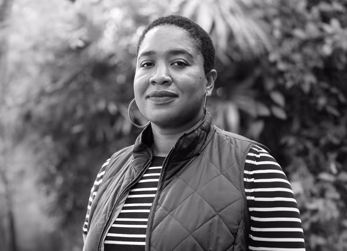 Black and white portrait of Jasmine McNealy standing outdoors. She is a researcher whose work centers on privacy and technology governance.