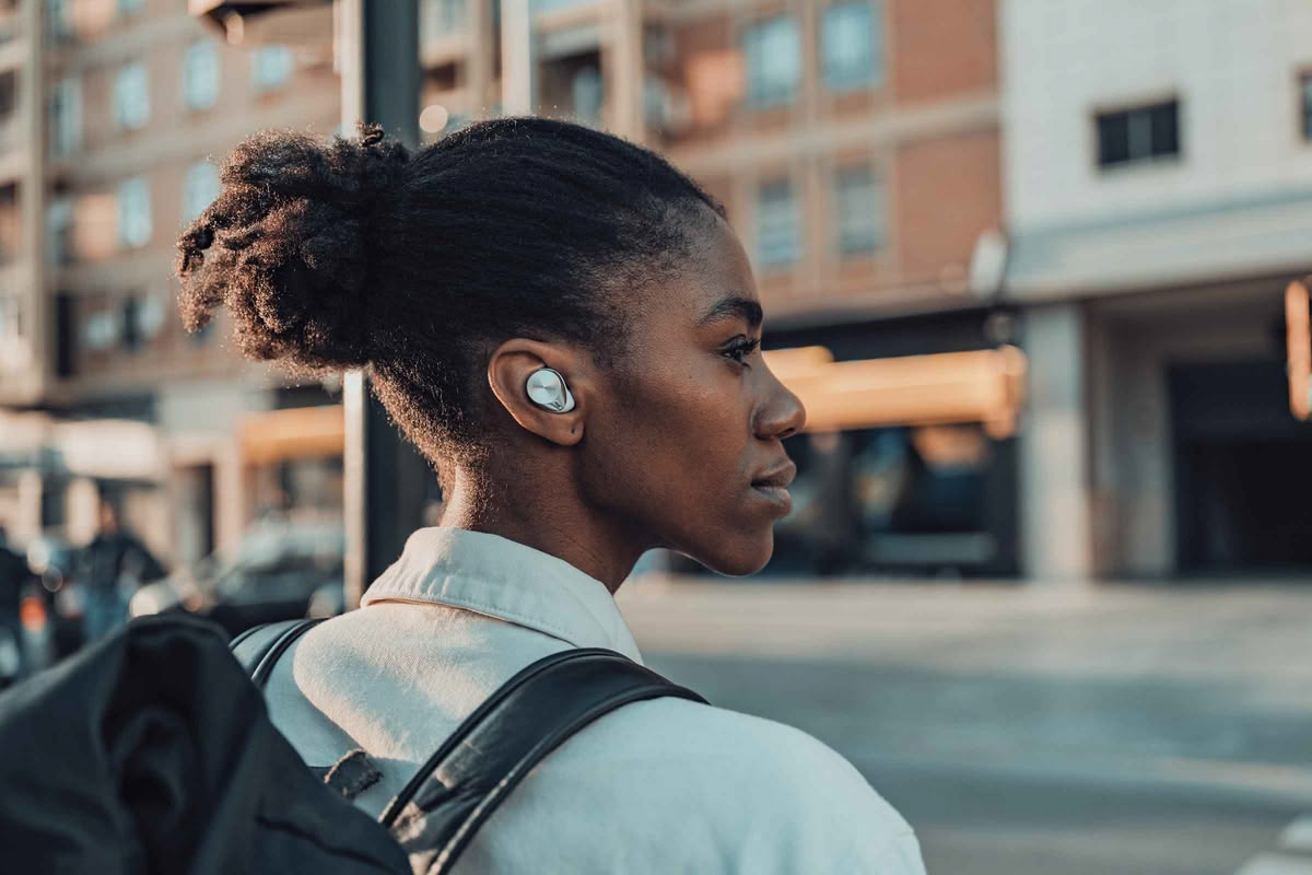 Young woman crossing the street with earphones.