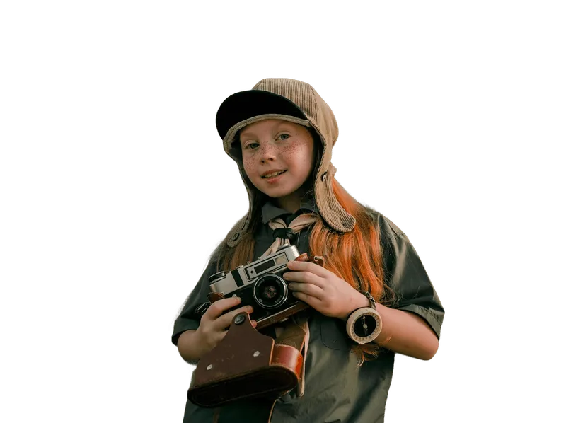 Young girl wearing a vintage aviator hat and scout uniform holding an old-fashioned camera.