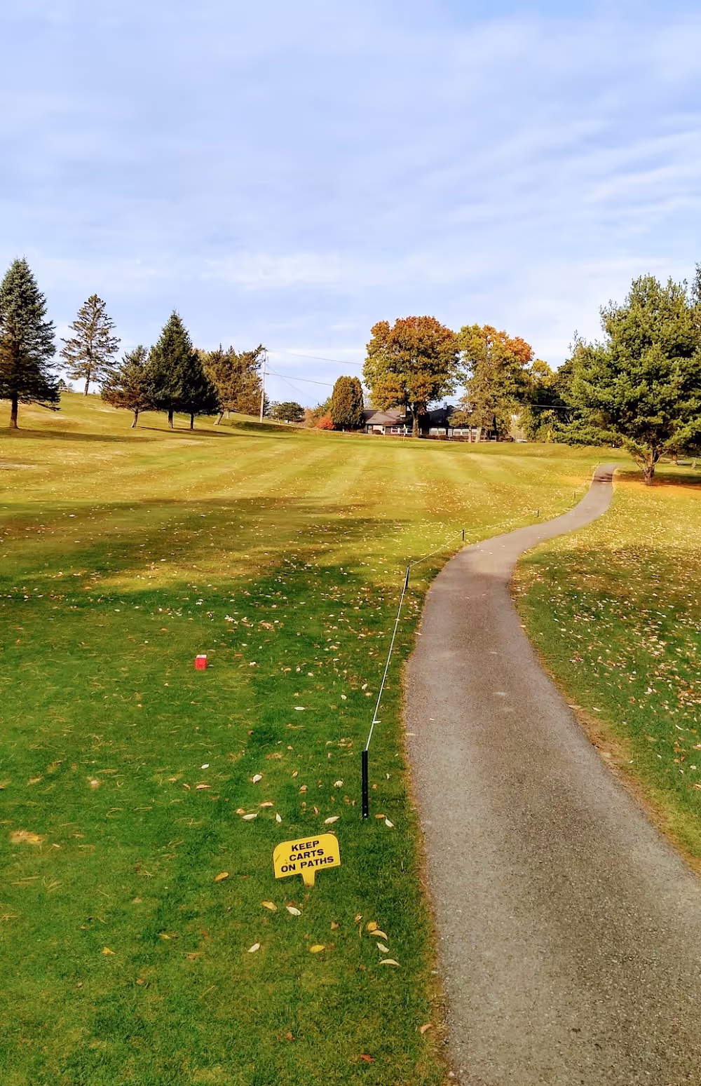 A sign on a pathway in a park.
