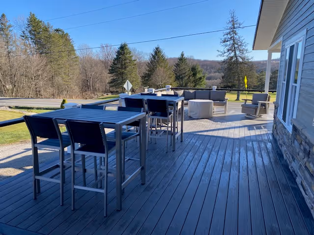 a table with chairs set on a balcony 