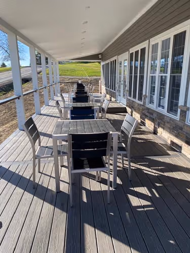 a table with chairs set on a balcony 