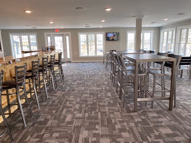 A large room with a bar and a television.
