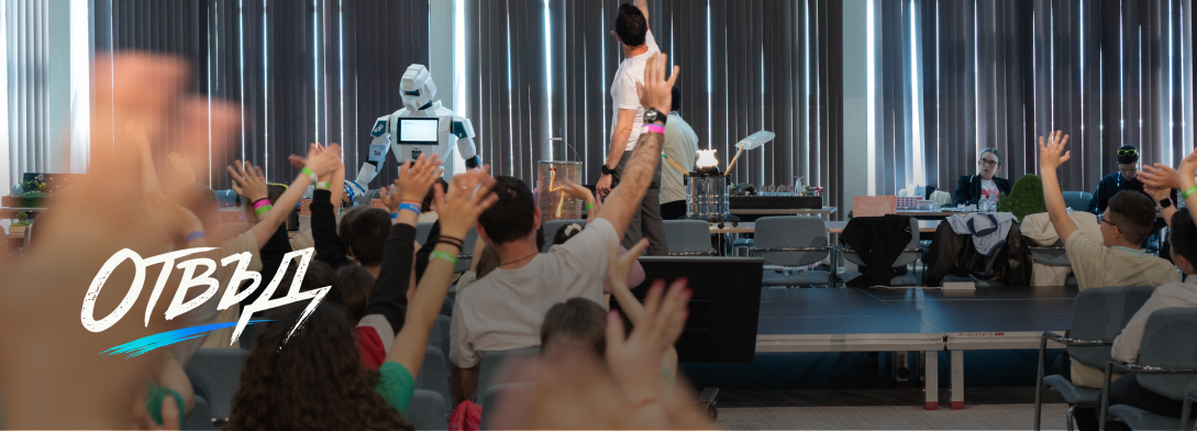 Audience with raised hands watching a humanoid robot and presenter in a modern conference room.