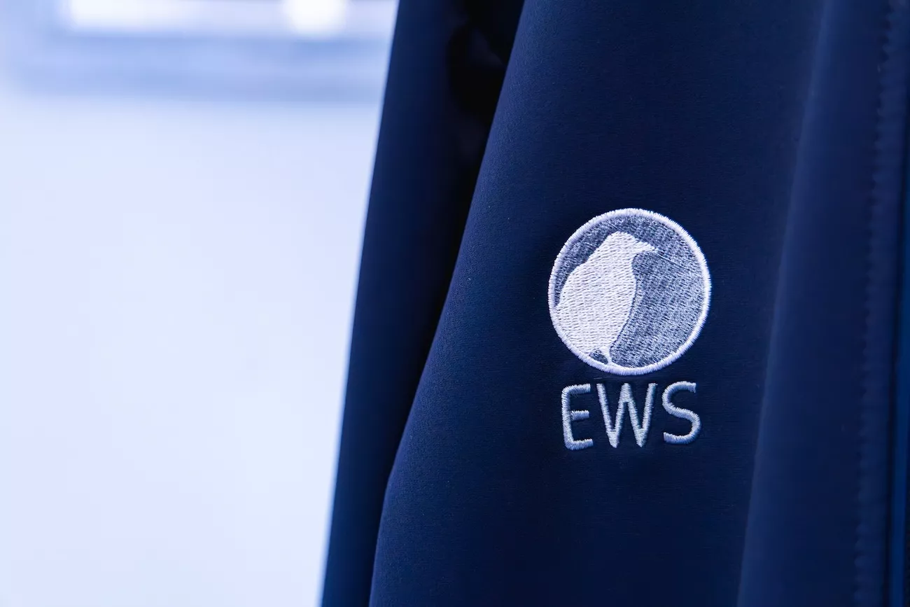 Embroidered EWS logo on a navy jacket, marking Alf Cupper's return as KSA In-Country Programme Manager.