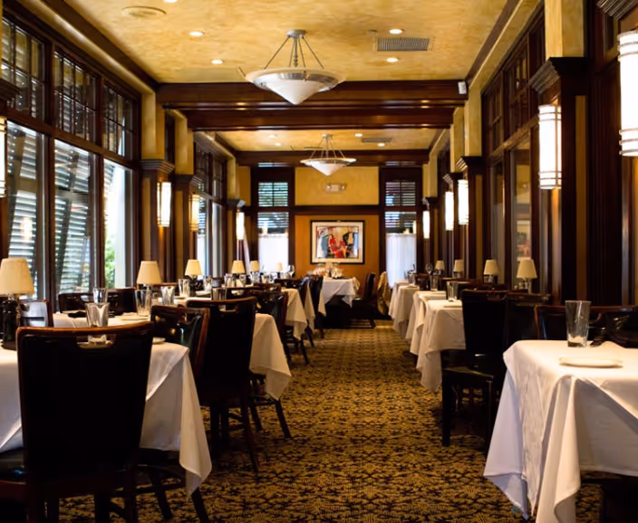 A restaurant with a large dining room and tables.