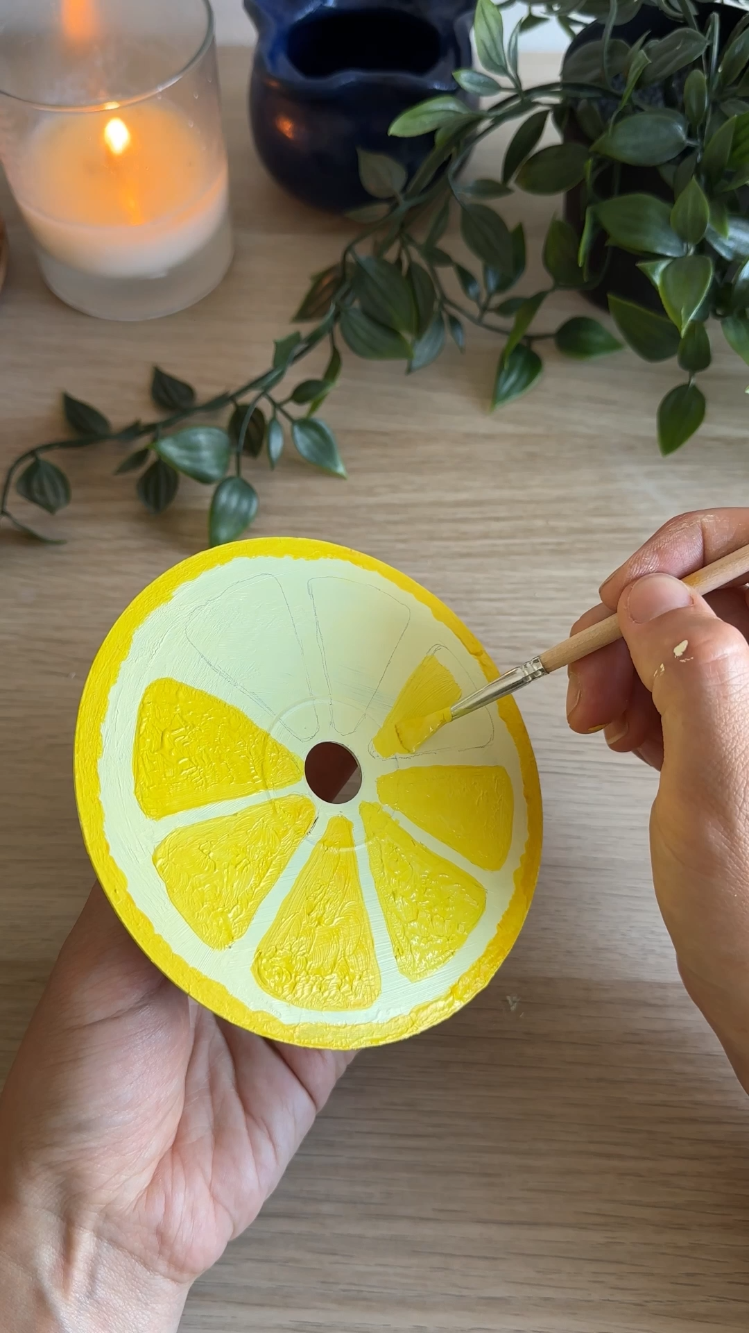 hand painting yellow citrus segments onto a diy upcycled cd lemon coaster
