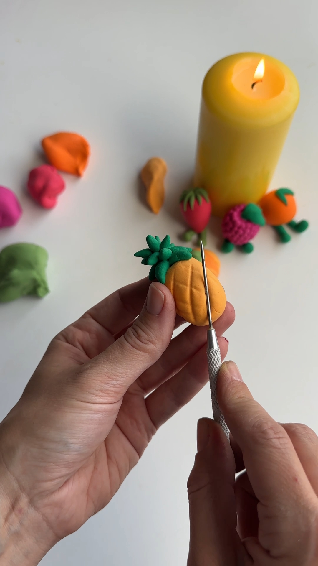 needle tool carving cross pattern into a foam clay pineapple