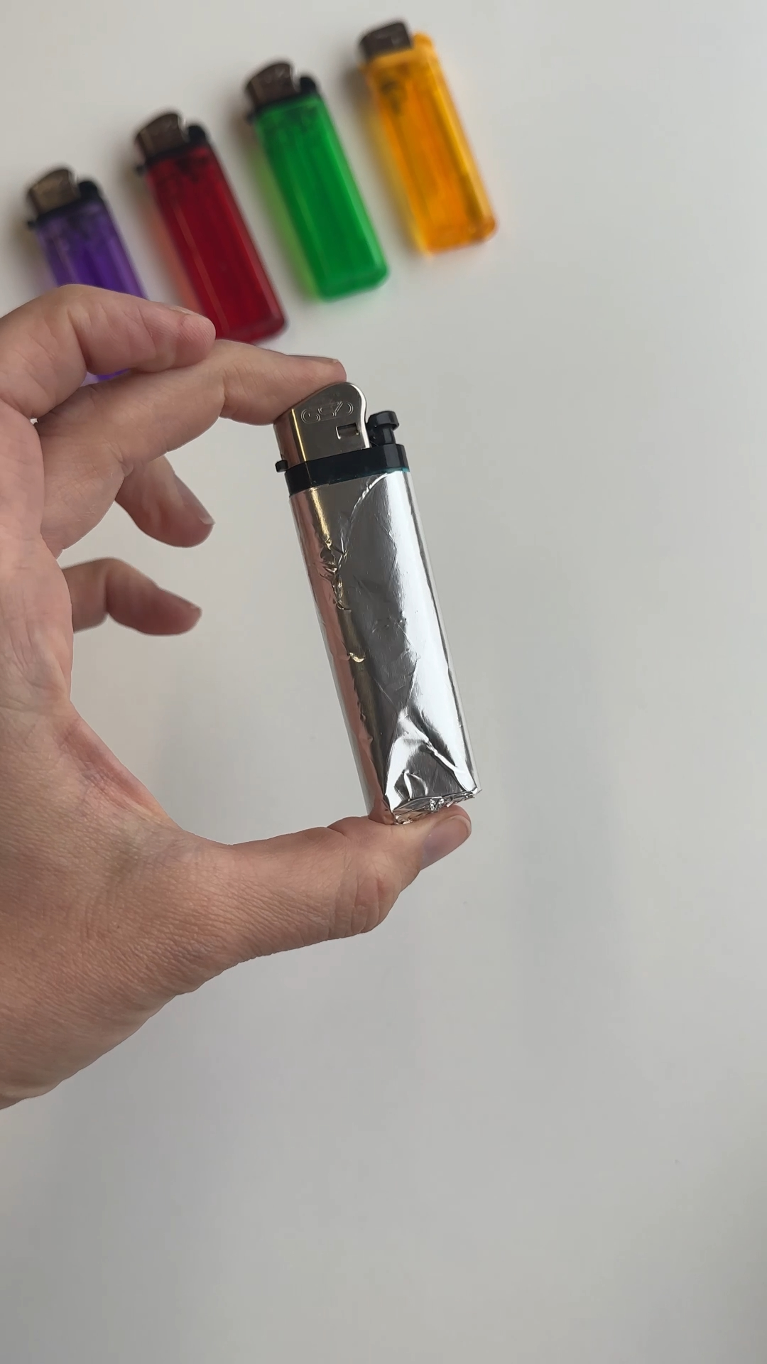 wrapping foil tightly around lighter to create removable inner layer