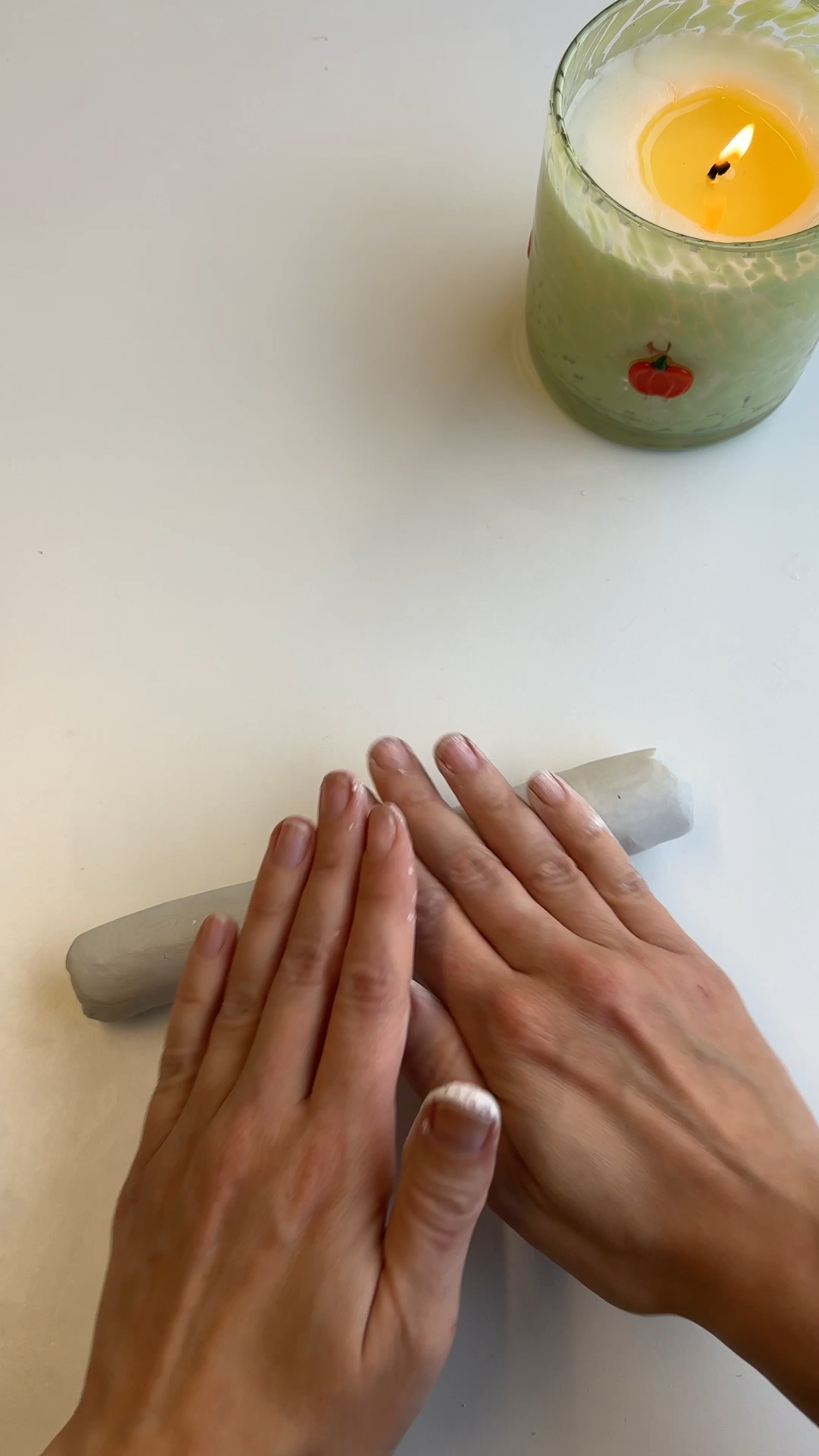 hands rolling air dry clay into even strip for bow base