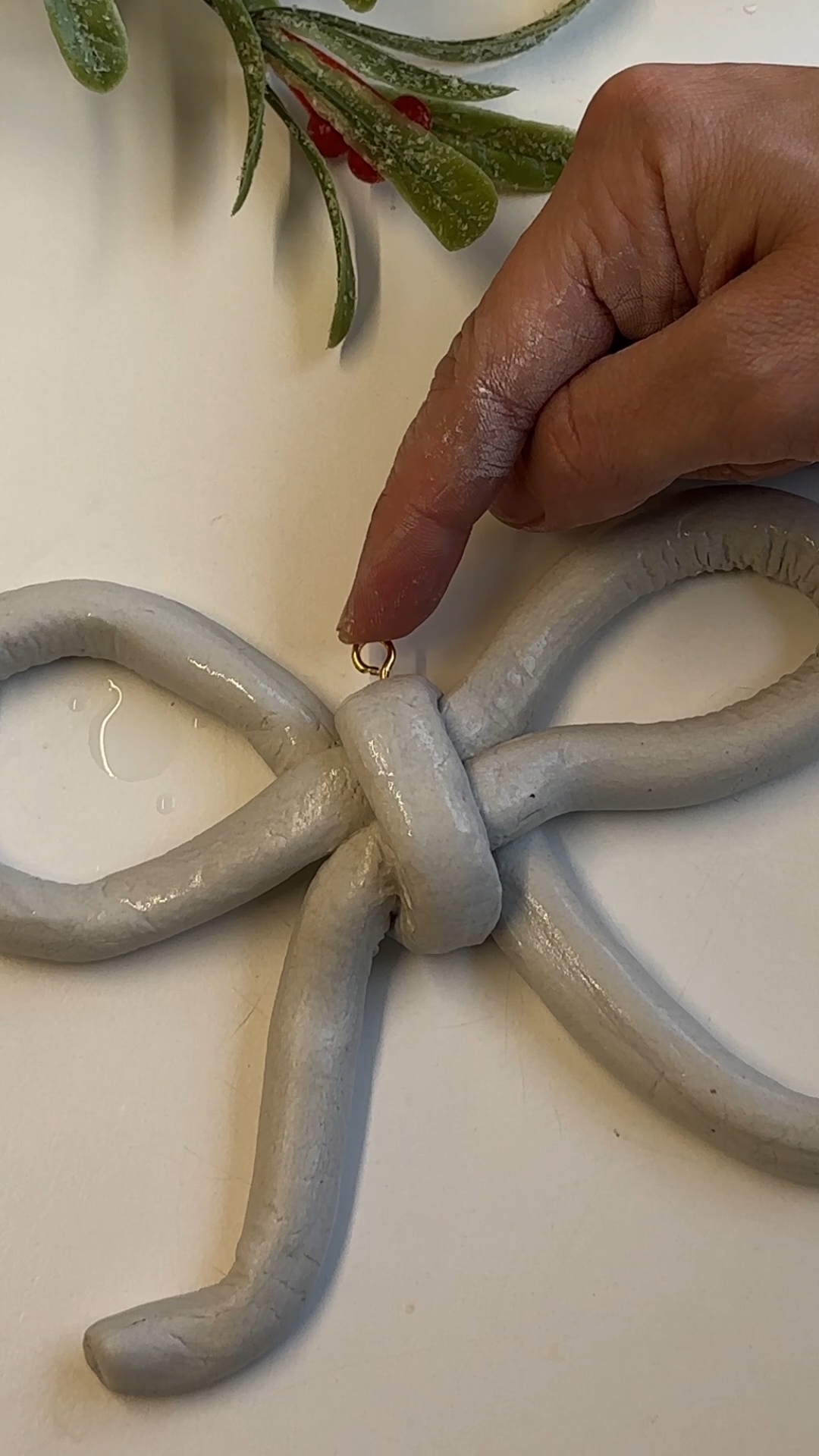 screwing eyelet into top of clay bow for hanging